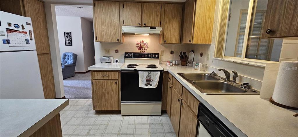 10881 Southwest 79th Terrace Ocala, FL 34476 - Photo 10 of 38 a kitchen with a sink stove and refrigerator