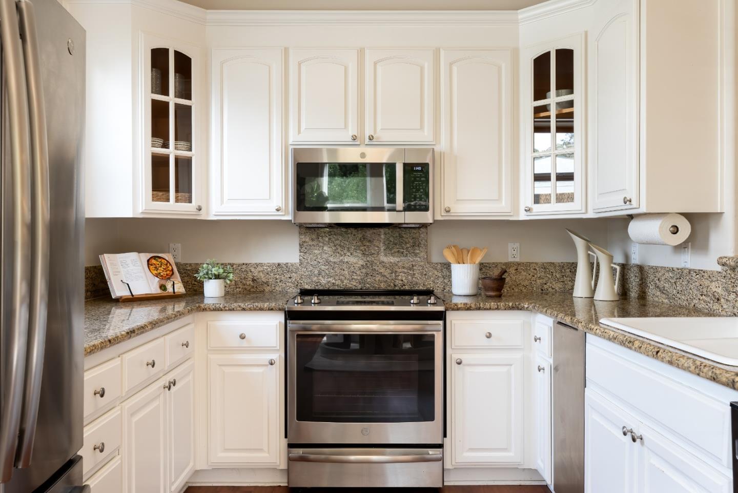 1237 Capuchino Avenue, Unit 7 Burlingame, CA 94010 - Photo 11 of 40 a kitchen with granite countertop white cabinets stainless steel appliances and sink