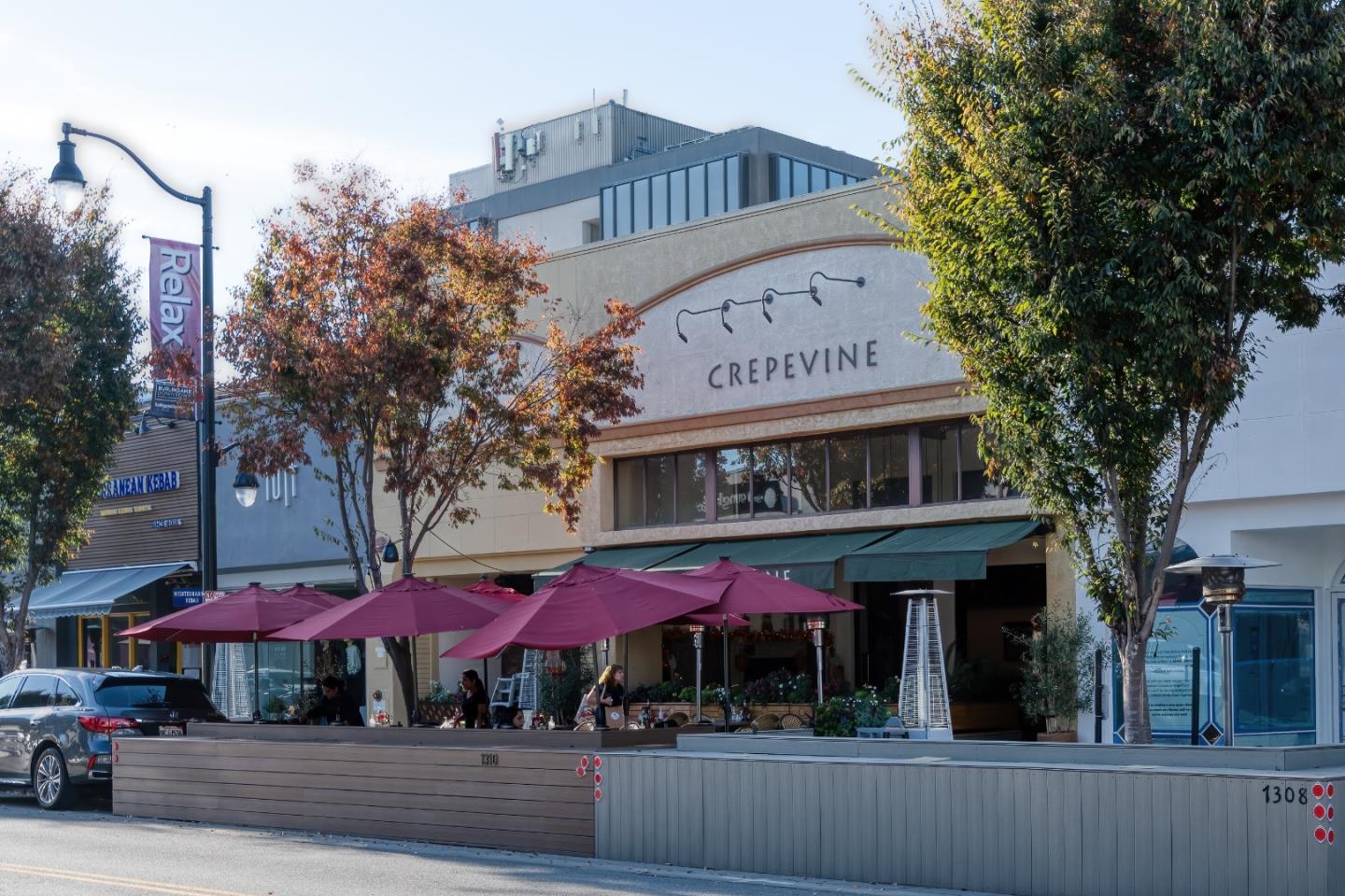 1237 Capuchino Avenue, Unit 7 Burlingame, CA 94010 - Photo 37 of 40 a view of a cafe with a table and chairs under an umbrella