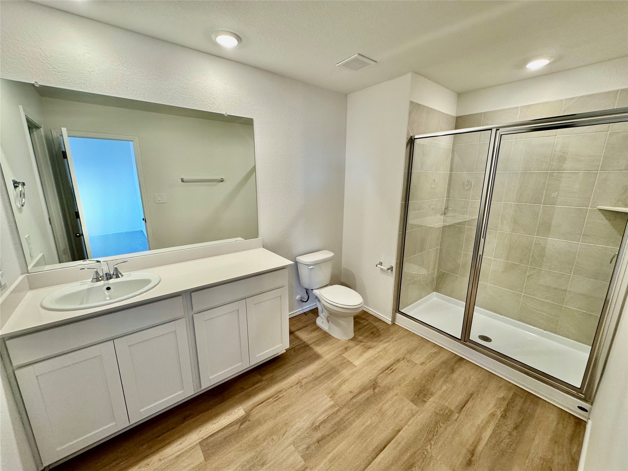 104 Calcite Road, Unit 2 Kyle, TX 78640 - Photo 4 of 21 Bathroom featuring vanity, a shower stall, and light wood finished floors