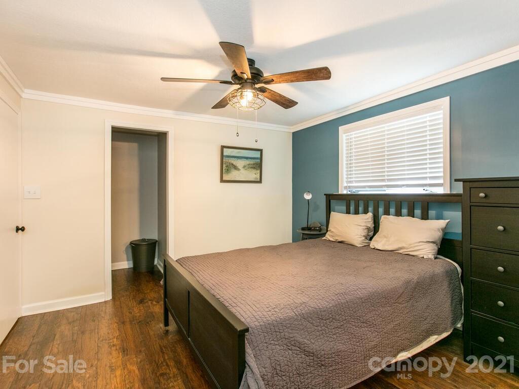 2044 Ridge Road Hendersonville, NC 28792 - Photo 22 of 37 a bedroom with a bed and a chandelier