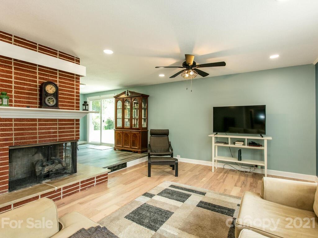 2044 Ridge Road Hendersonville, NC 28792 - Photo 8 of 37 a living room with furniture a flat screen tv and a fireplace