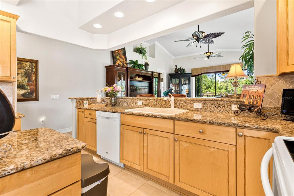 26142 Avenida Las Colinas, Unit 2B Howey-in-the-Hills, FL 34737 - Photo 25 of 78 a kitchen with kitchen island granite countertop a sink cabinets and window