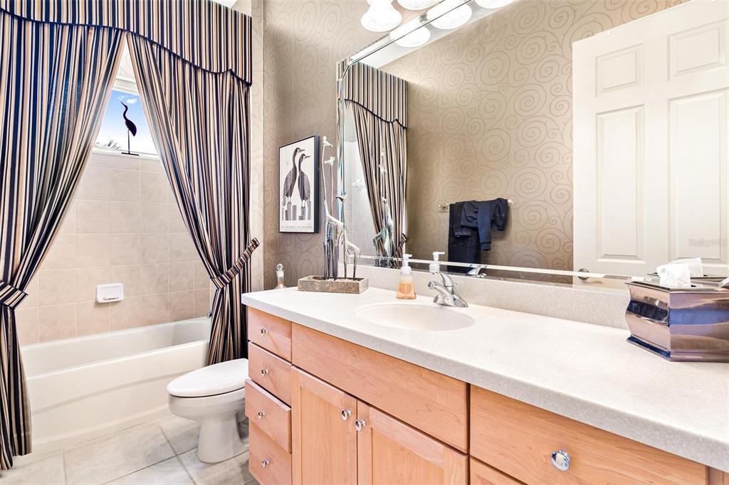 26142 Avenida Las Colinas, Unit 2B Howey-in-the-Hills, FL 34737 - Photo 52 of 78 a bathroom with a sink a toilet and a large mirror