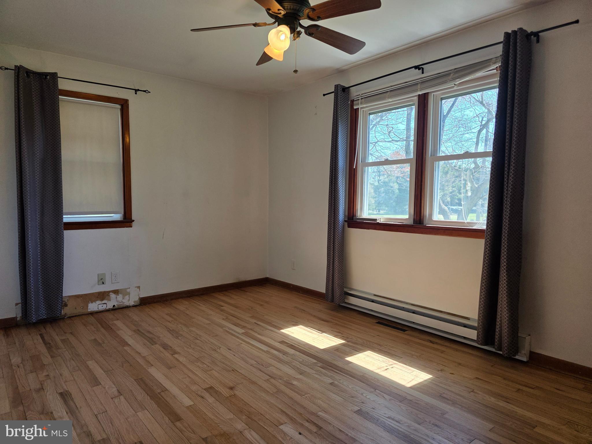 697 West Denneys Road Dover, DE 19904 - Photo 9 of 16 an empty room with wooden floor and windows