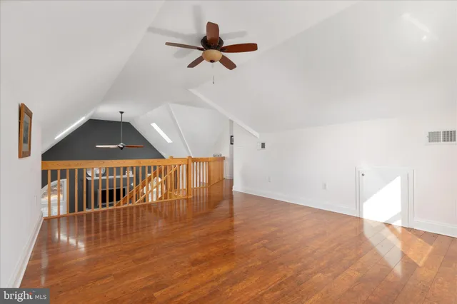an empty room with a window and a ceiling fan