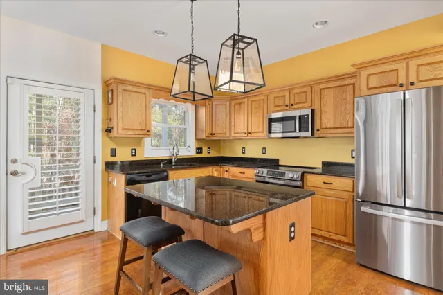 a kitchen with stainless steel appliances a stove a refrigerator and a sink