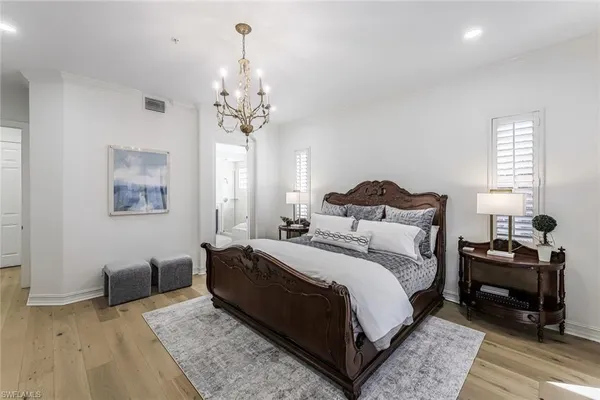 a bedroom with bed and a chandelier