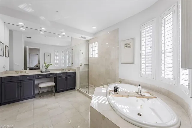 a large bathroom with a tub a double vanity sink a window and a mirror