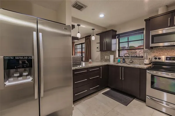a kitchen with stainless steel appliances granite countertop a refrigerator and a sink