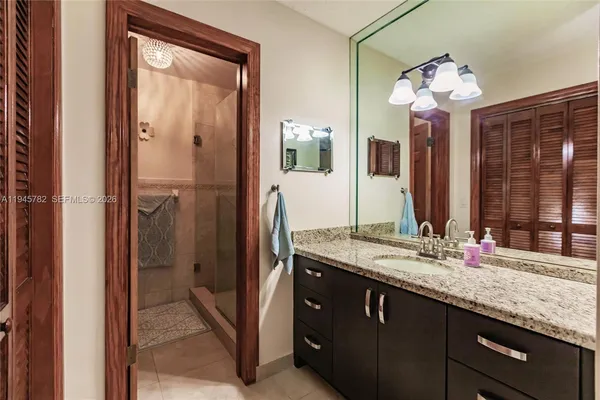 a bathroom with a granite countertop sink and a mirror