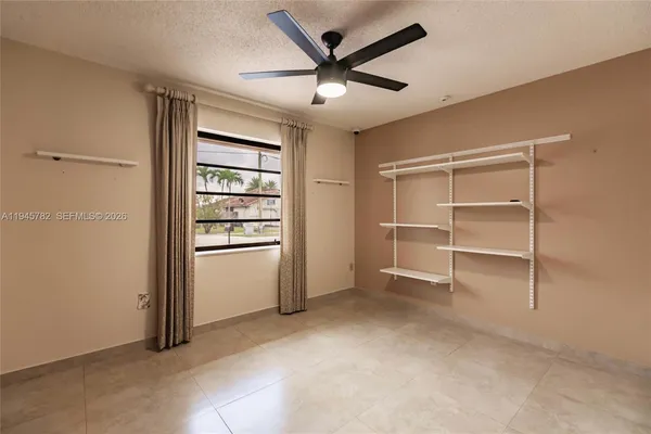 a view of an empty room and a ceiling fan