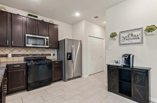a kitchen with granite countertop stainless steel appliances and wooden cabinets