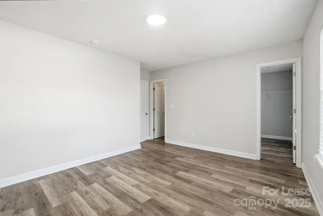 an empty room with wooden floor and bathroom