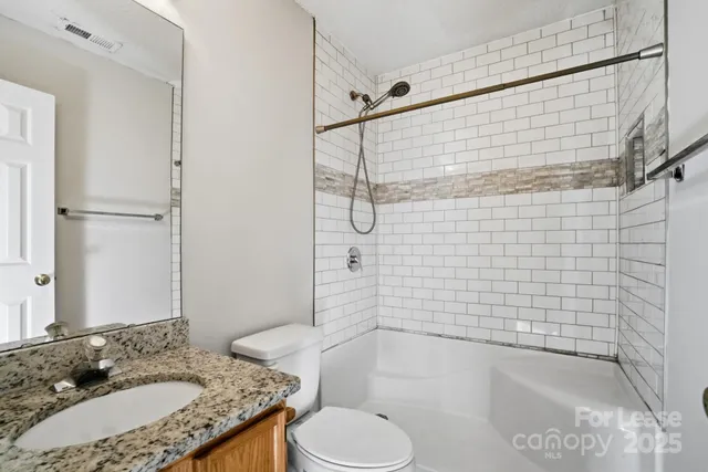 a bathroom with a granite countertop sink toilet and shower