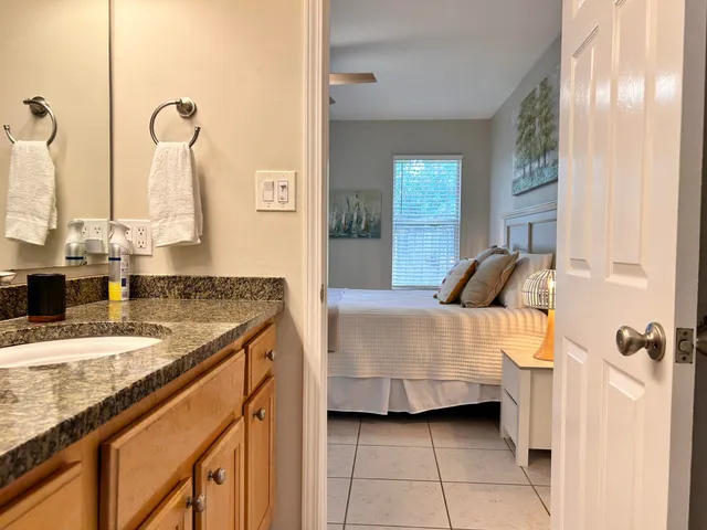 a bedroom with a granite countertop sink and a mirror