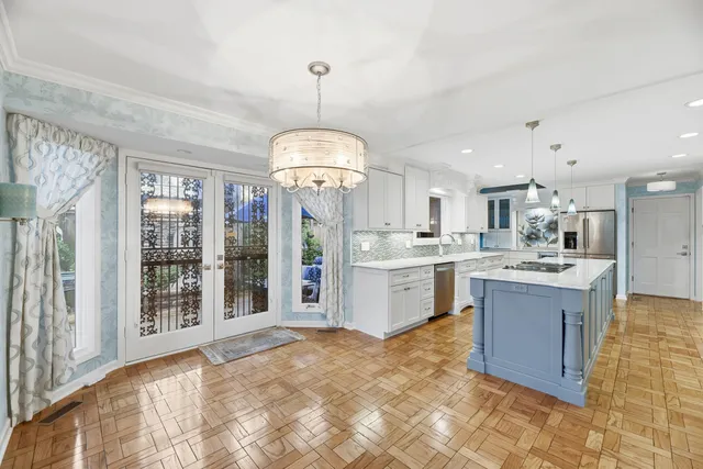 a large kitchen with kitchen island a chandelier stainless steel appliances and a chandelier