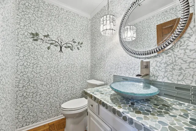 a bathroom with a granite countertop toilet a sink and a mirror