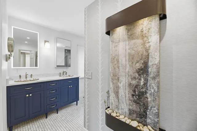 a bathroom with a granite countertop sink a mirror and shower