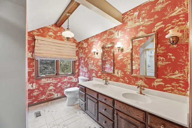 a bathroom with a sink mirror and toilet
