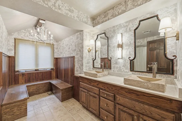 a spacious bathroom with double vanity and a mirror