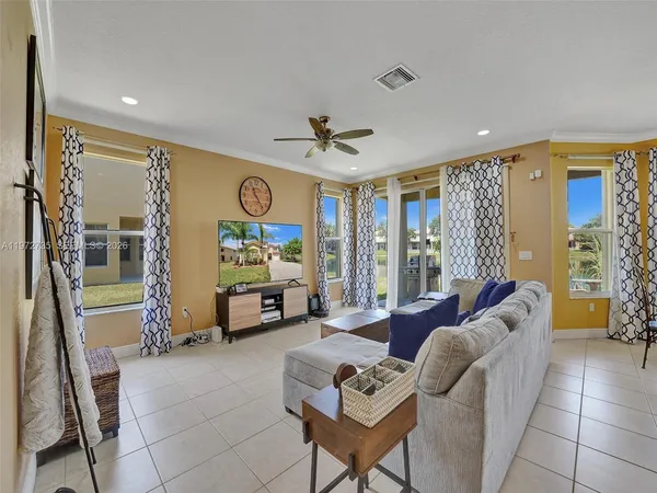 a living room with furniture a large window and a chandelier