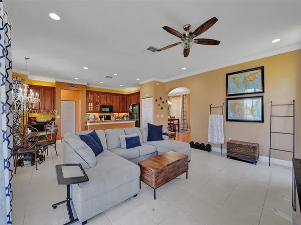 a large living room with stainless steel appliances kitchen island granite countertop a large kitchen island a stove a sink a dining table and chairs with wooden floor