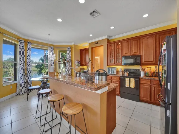 a large kitchen with stainless steel appliances a sink and large window
