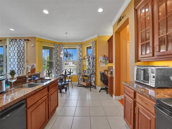 a kitchen with granite countertop a sink and a refrigerator