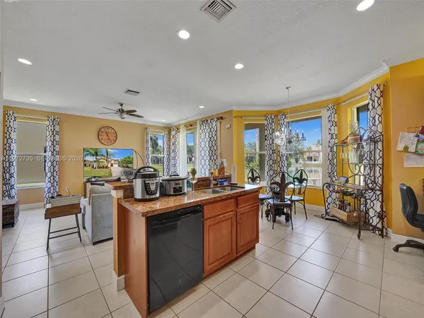 a kitchen with stainless steel appliances granite countertop a refrigerator and a stove top oven