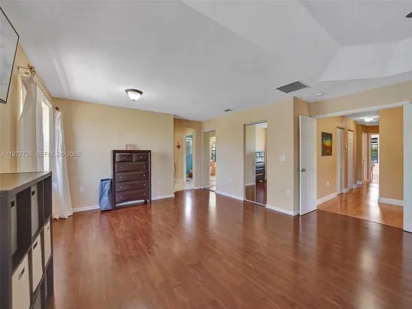 a view of a hallway with a livingroom and a mirror
