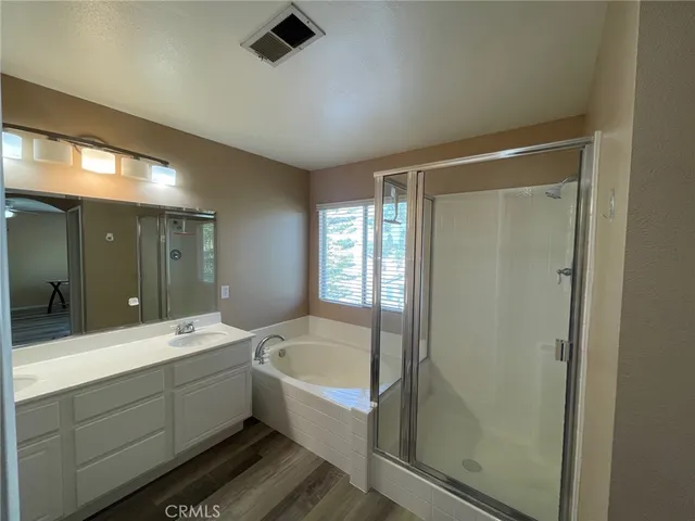 a bathroom with a double vanity sink a mirror and a bathtub