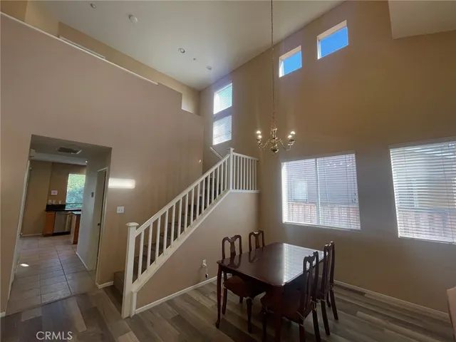 a view of a a dining room with furniture window and wooden floor