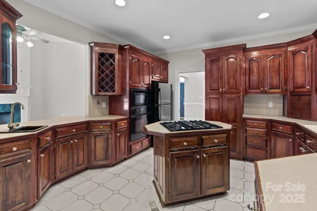 a kitchen with stainless steel appliances granite countertop a stove refrigerator and cabinets