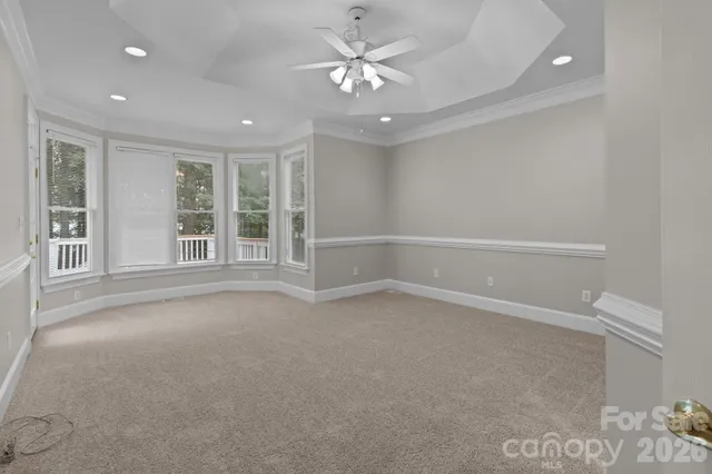 a view of wooden deck and lake with trees in the background