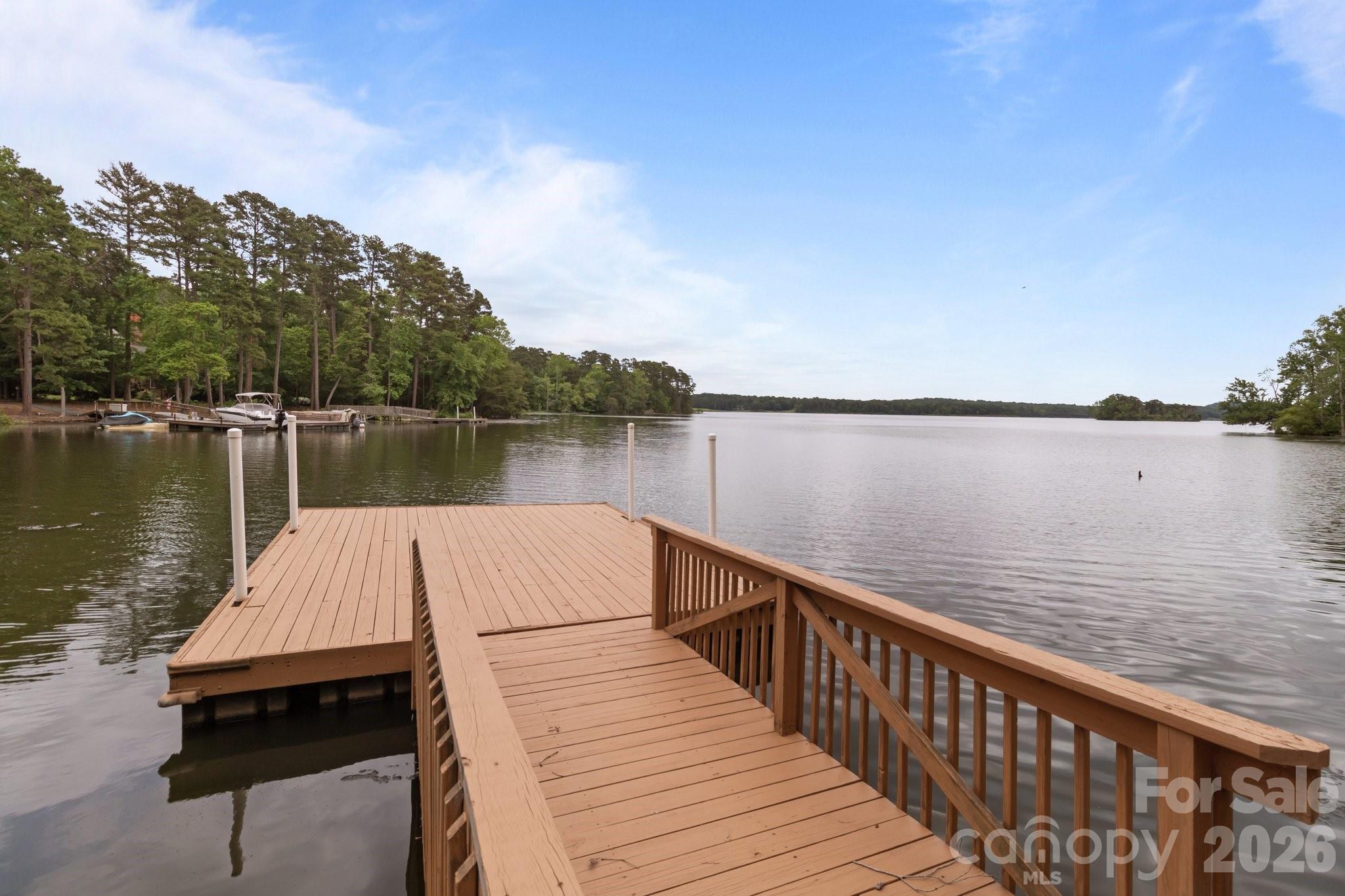 165 Futrell Landing New London, NC 28127 - Photo 42 of 48 a view of wooden deck and lake with trees in the background
