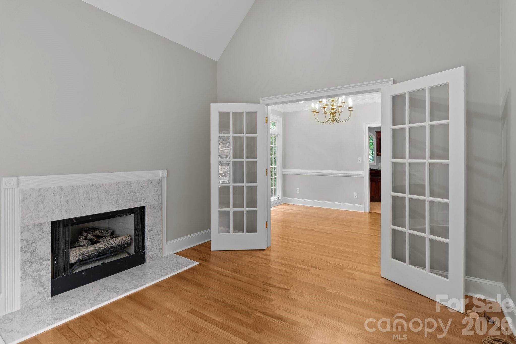 165 Futrell Landing New London, NC 28127 - Photo 8 of 48 an empty room with wooden floor fireplace and windows