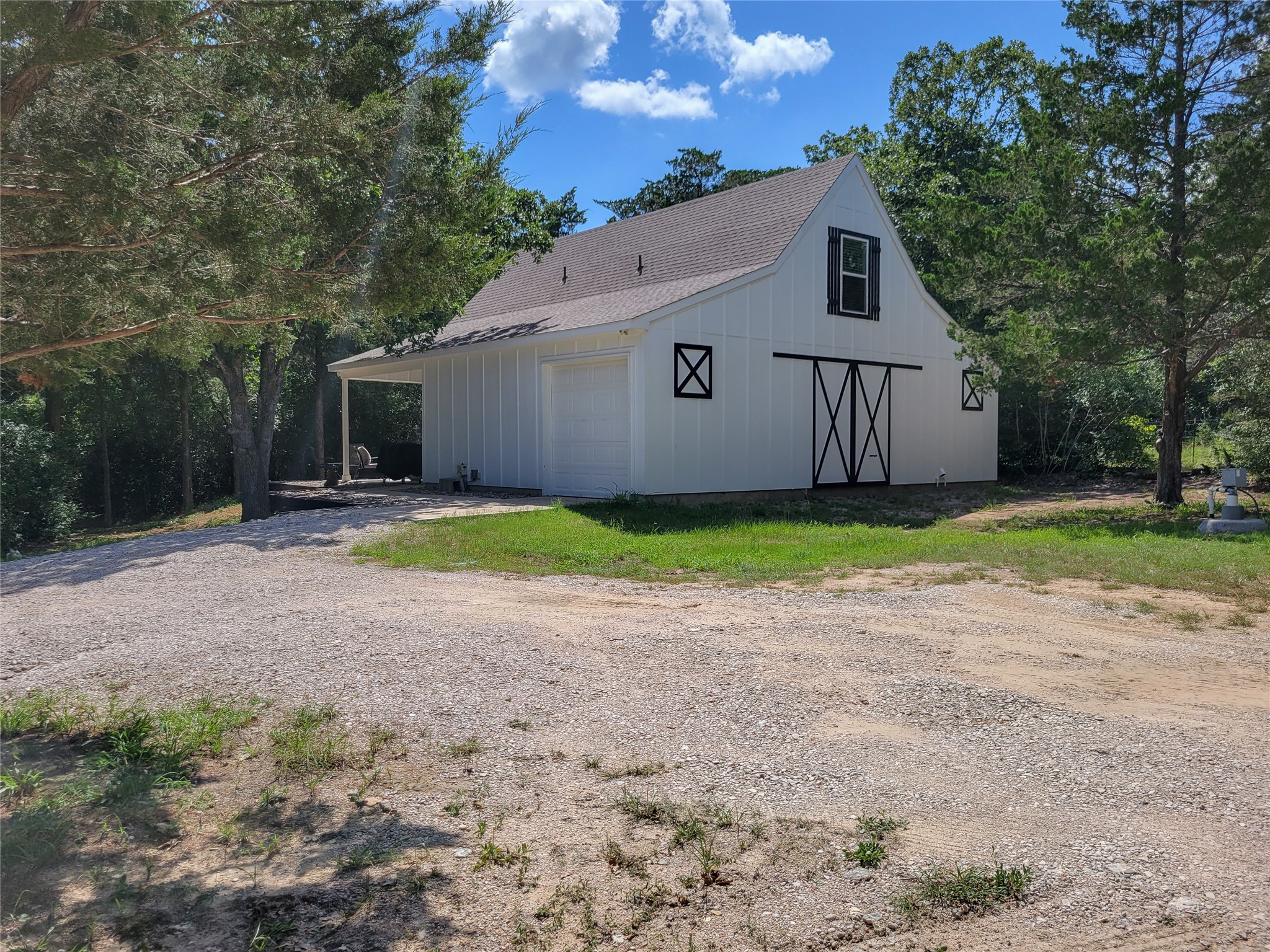 4937 Wolff Road Round Top, TX 78954 - Photo 3 of 31 Charming front view with durable white board siding, highlighted by elegant black trim and a stylish barn door.