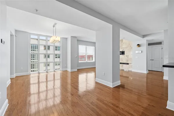 a view of an empty room with window and wooden floor