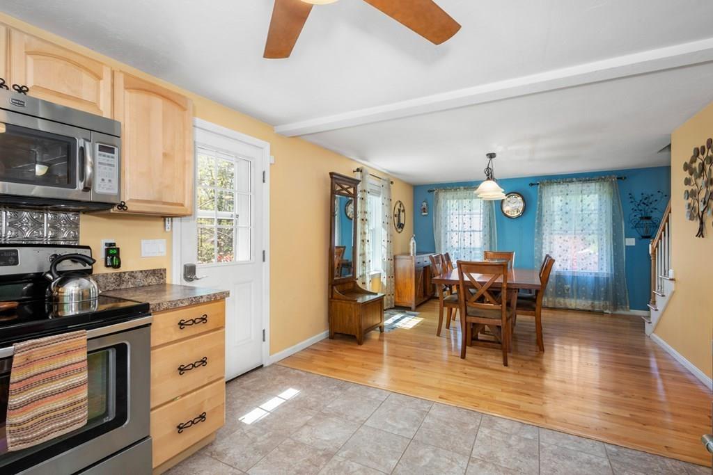 96 Sturbridge Road Holland, MA 01521 - Photo 10 of 25 a kitchen with stainless steel appliances granite countertop a stove top oven a sink a dining table and chairs with wooden floor