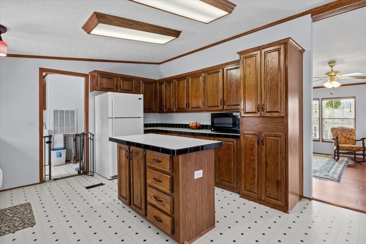 1644 West Blue Creek Road Waverly, TN 37185 - Photo 27 of 61 a kitchen with stainless steel appliances granite countertop a stove a refrigerator and a sink with wooden cabinets
