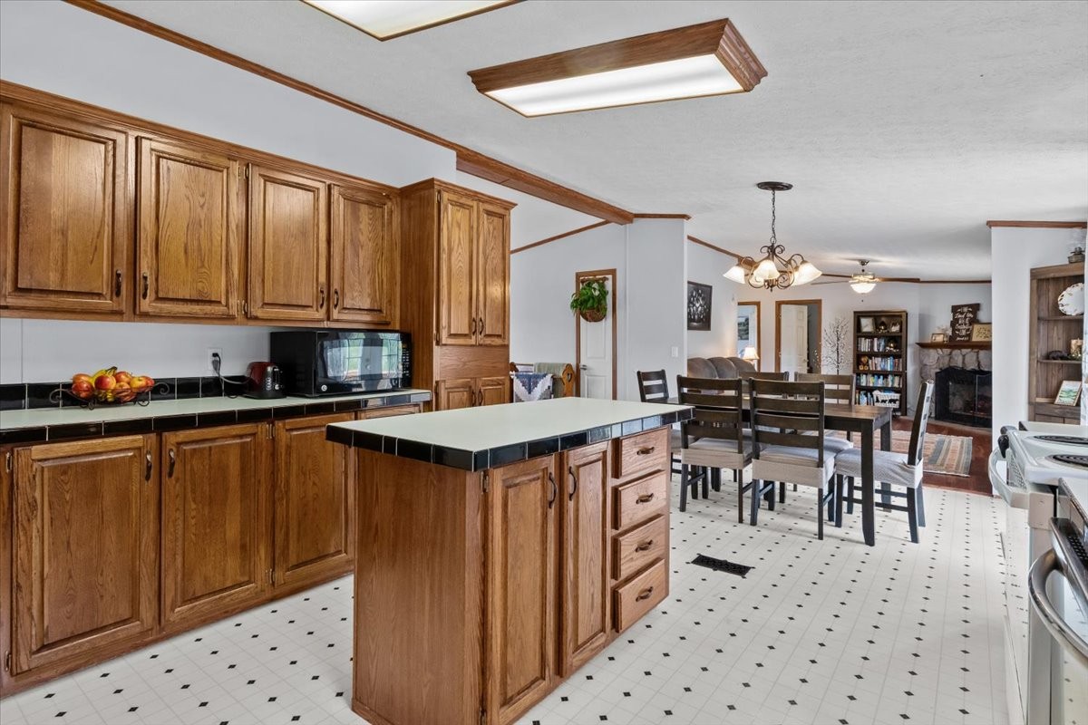 1644 West Blue Creek Road Waverly, TN 37185 - Photo 29 of 61 a kitchen with stainless steel appliances a table chairs refrigerator and cabinets