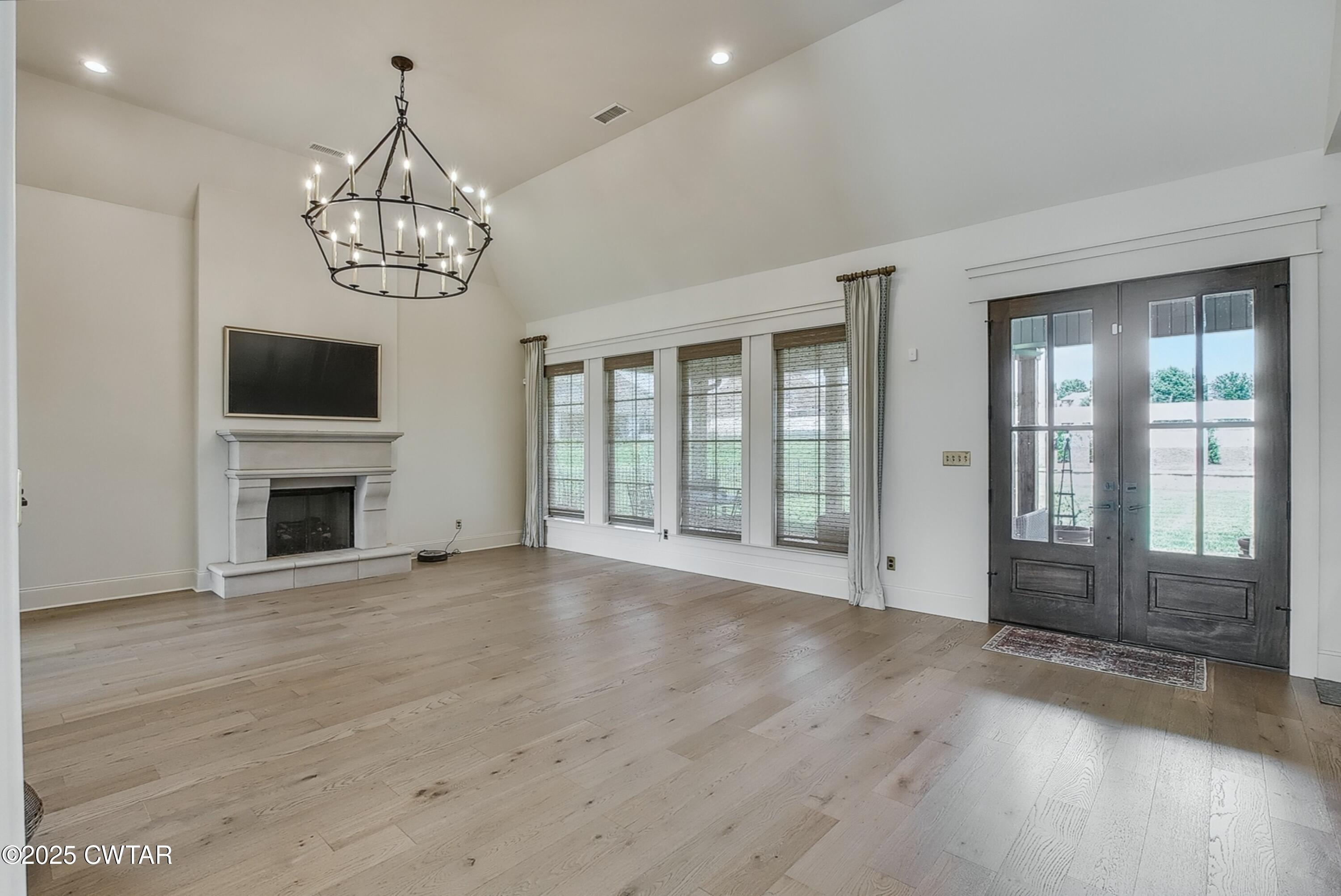 52 Buckingham Cove Jackson, TN 38305 - Photo 11 of 33 a view of a livingroom with a fireplace wooden floor and chandelier