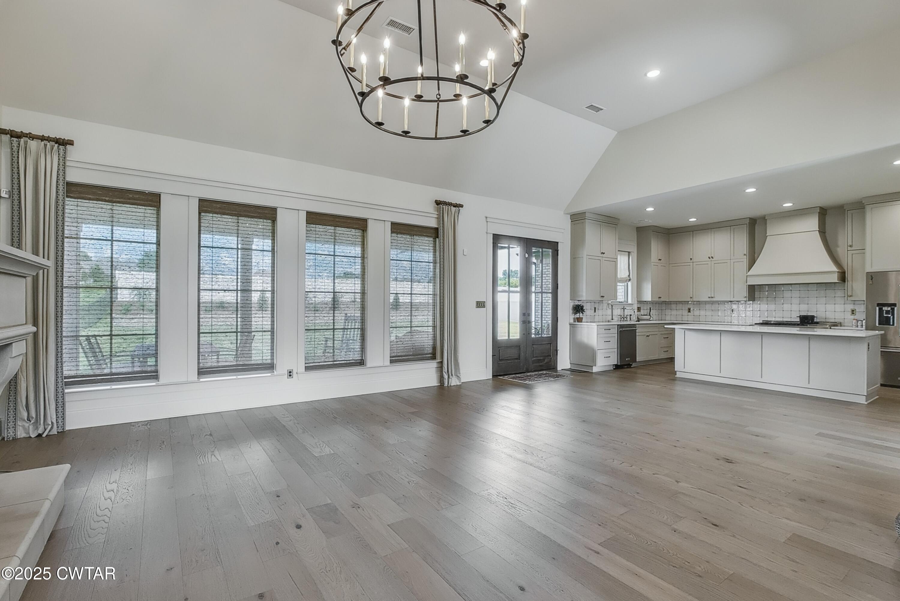 52 Buckingham Cove Jackson, TN 38305 - Photo 12 of 33 a view of an empty room with wooden floor and a kitchen