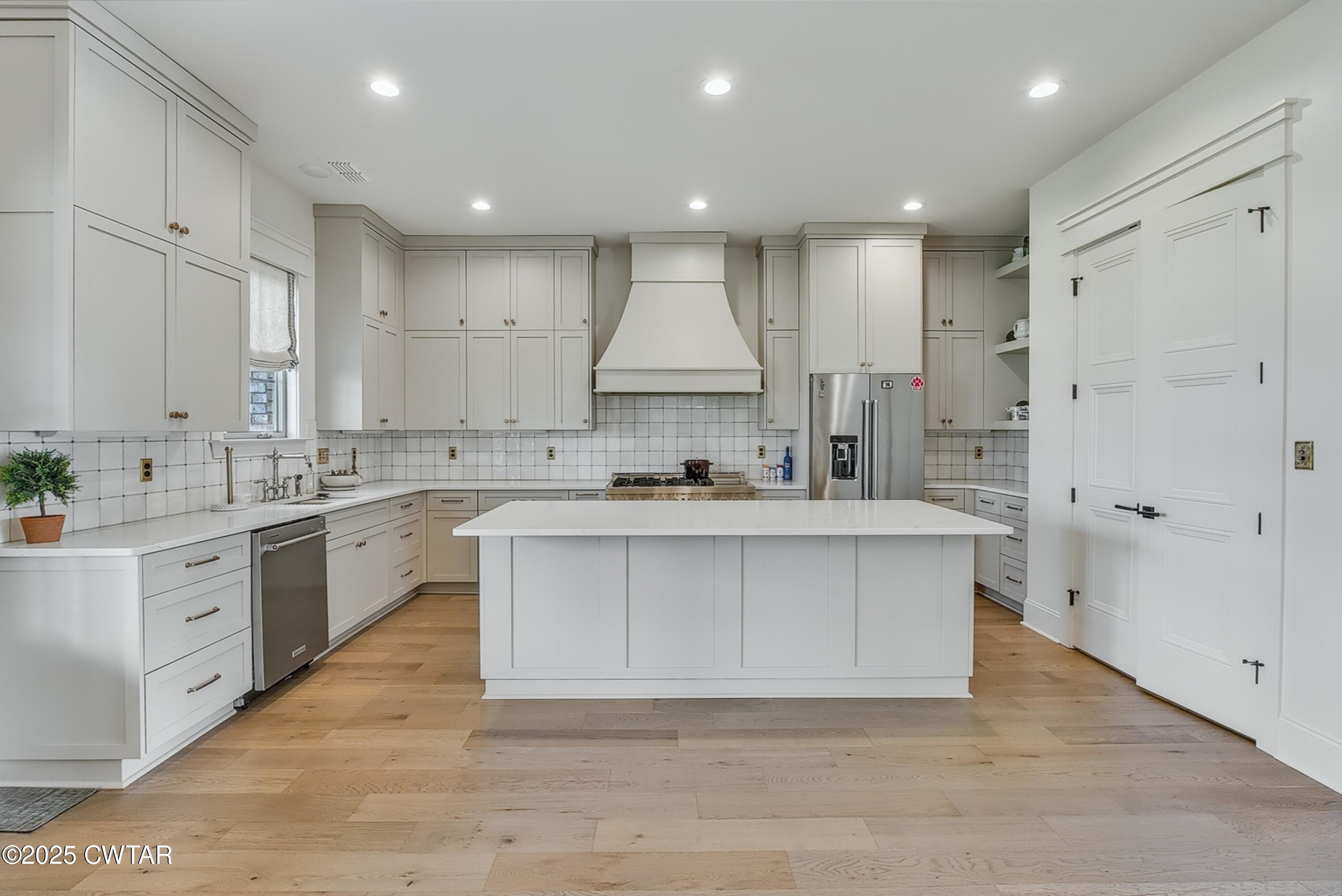 52 Buckingham Cove Jackson, TN 38305 - Photo 15 of 33 a large white kitchen with kitchen island a sink stainless steel appliances and white cabinets