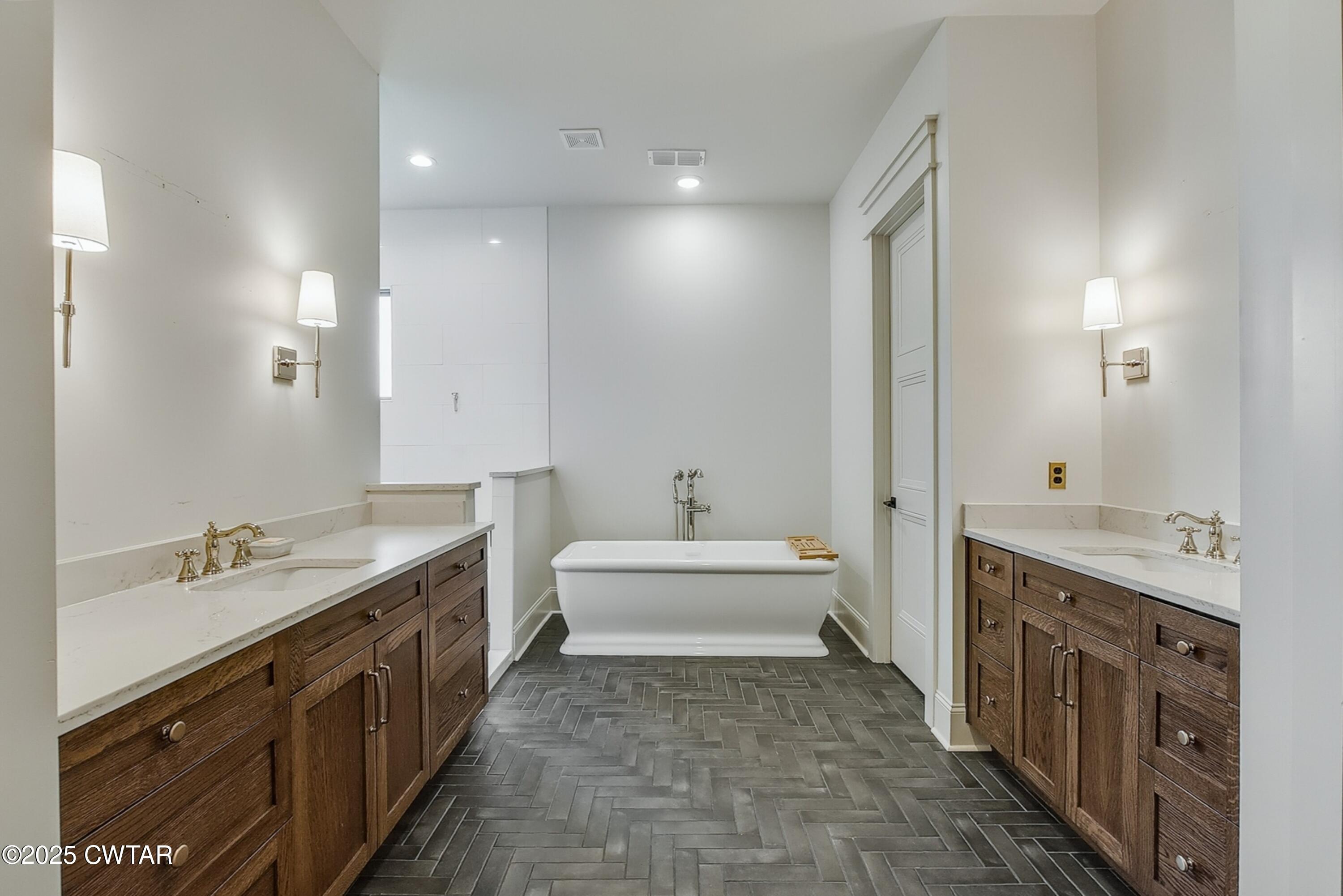 52 Buckingham Cove Jackson, TN 38305 - Photo 19 of 33 a spacious bathroom with a double vanity sink a mirror and a bathtub