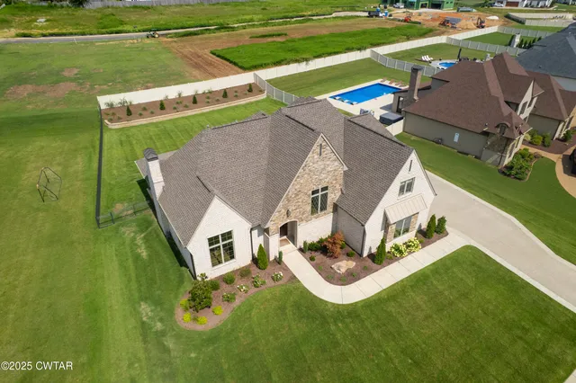 an aerial view of a house with a garden and swimming pool