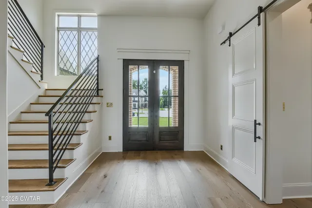 a view of an entryway with wooden floor and door