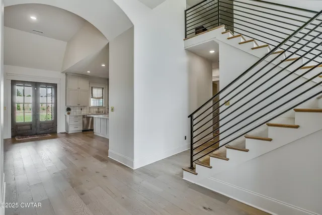 an entryway in a hall with a window and wooden floor