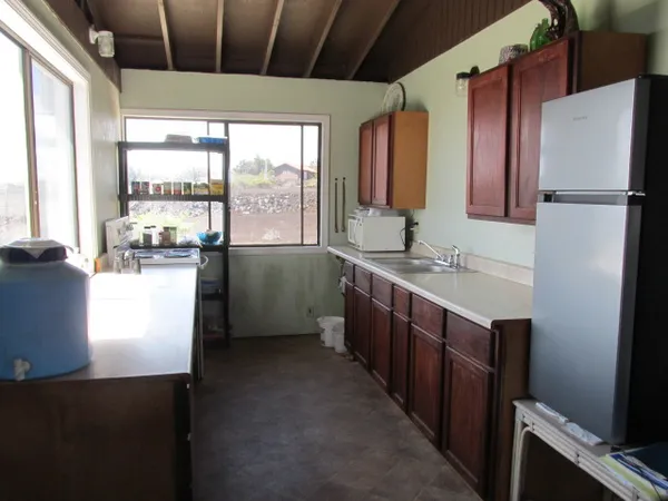 a kitchen with kitchen island a counter top space wooden floor and a large window